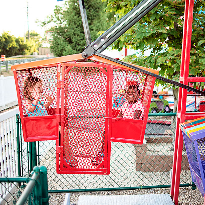 Two kids ride on the ferris wheel.
