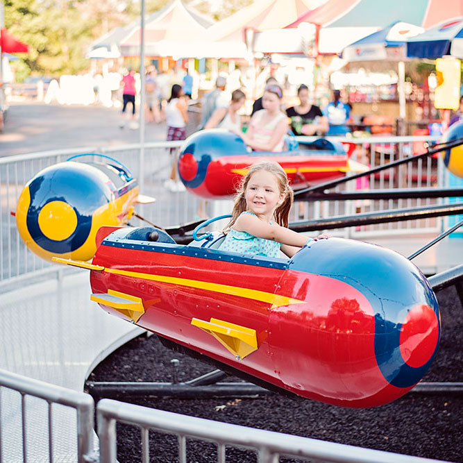 Young girl rides the Sky Fighters ride